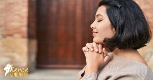Woman holding hands under chin in thanks