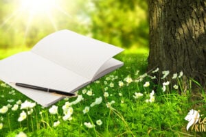 Spring Journal for prompts and pen on flowery background with tree