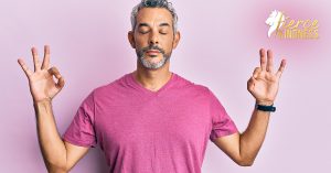 Man staying Calm meditating wearing pink t-shirt on pink background