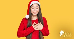Happy woman wearing santa hat smiling with hands over heart for holiday gifts article