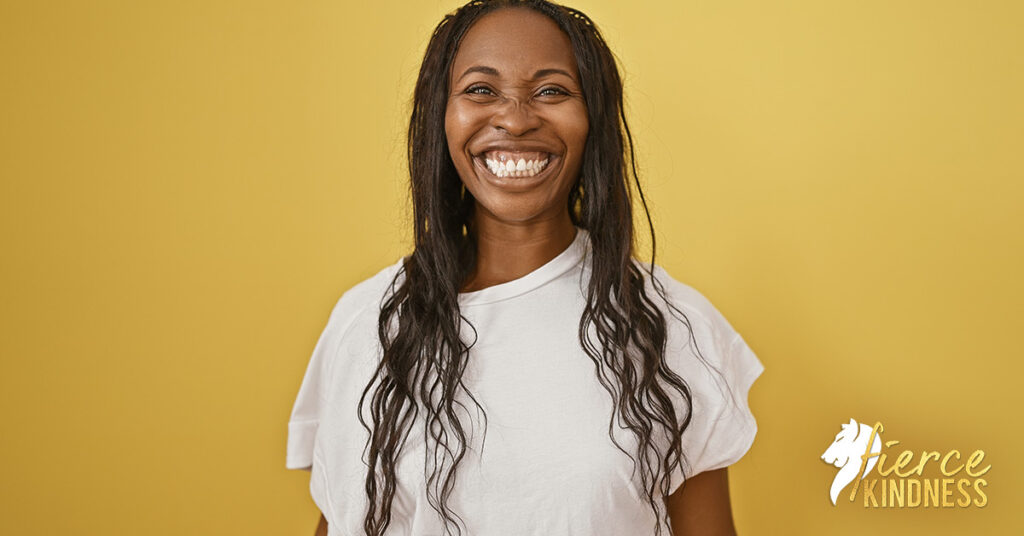 Joyful woman in white shirt against gold background
