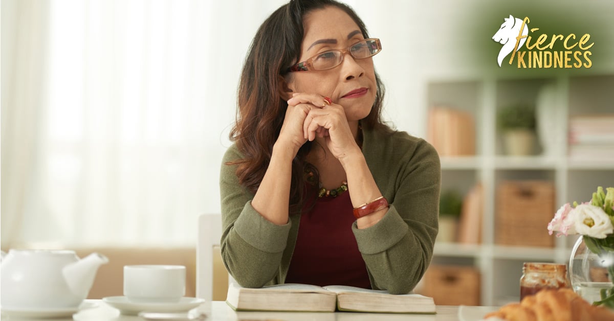 Mature Woman procrastinating thinking with tea, food and a book