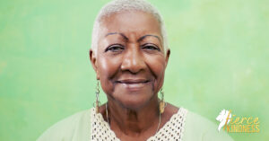 Older Black woman smiling against green background