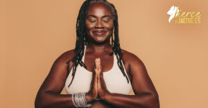 Calm serene woman smiling with hands together against a beige background