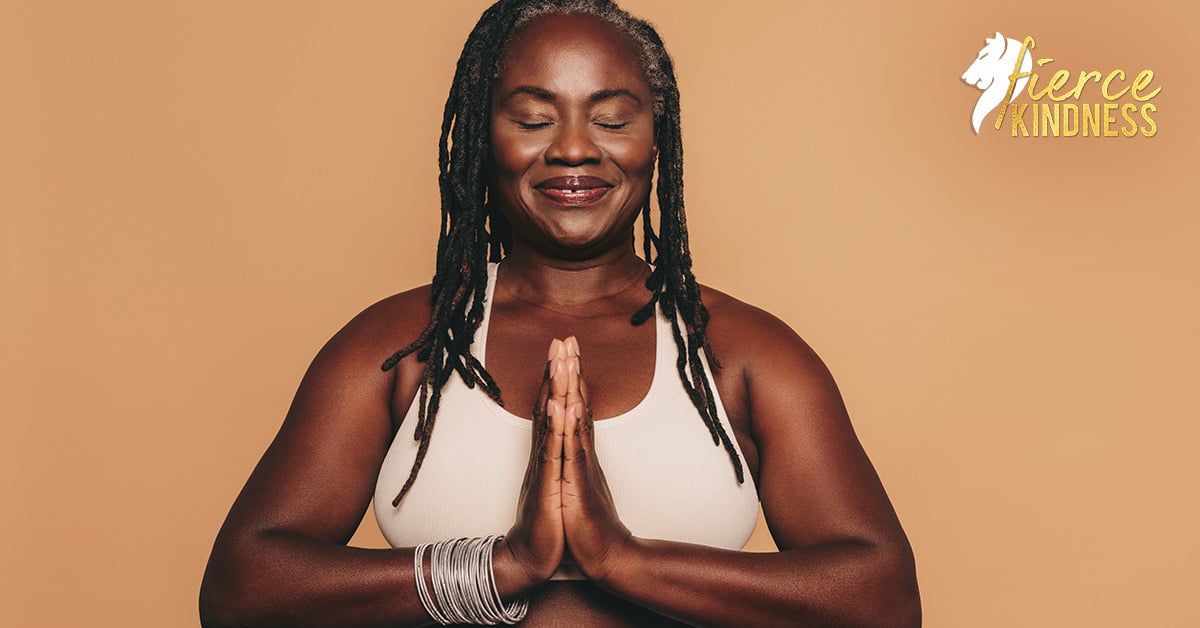Calm serene woman smiling with hands together against a beige background