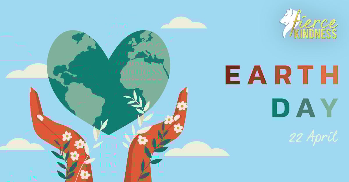 Green Heart Shaped Earth held in Hands with flowers saying Earth Day