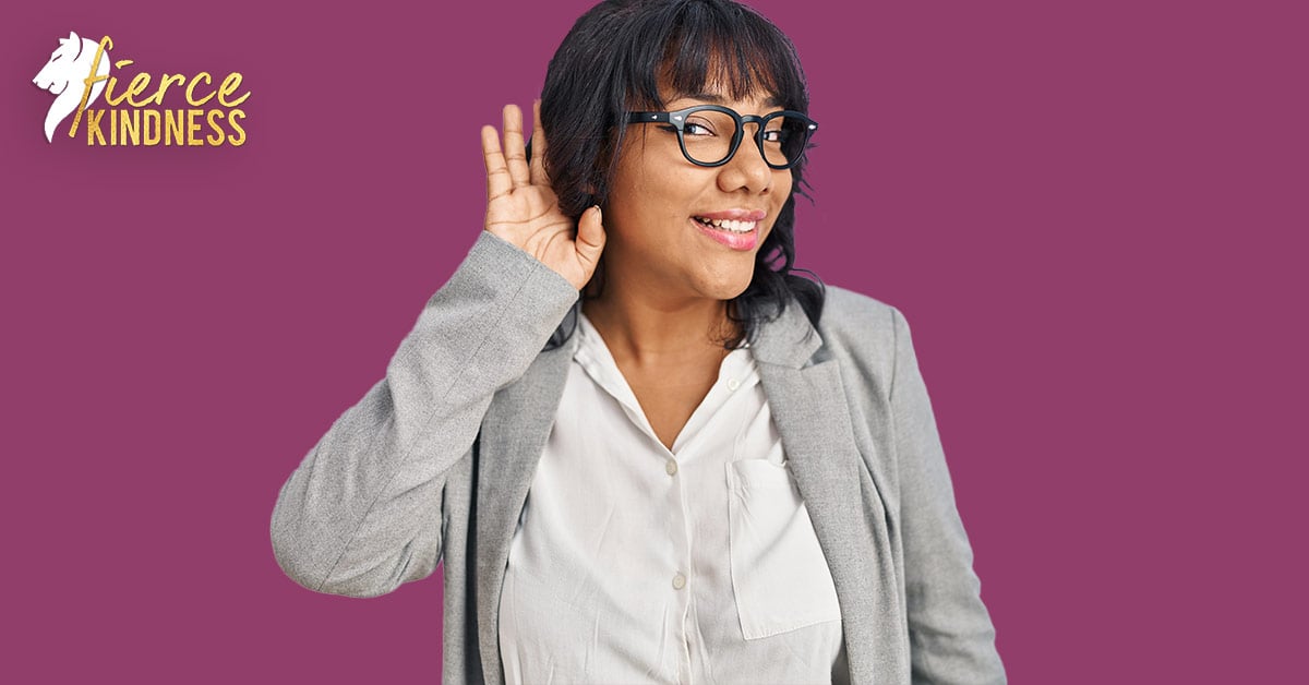 Smiling woman in glasses with hand behind ear to show she is listening